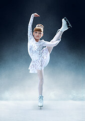 Image showing Little girl figure skating at the indoor ice arena.