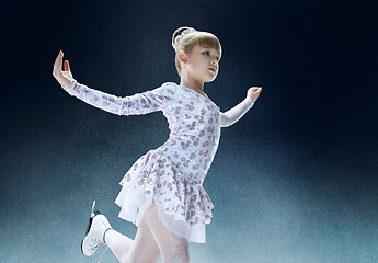 Image showing Little girl figure skating at the indoor ice arena.