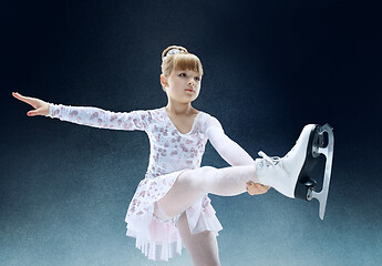 Image showing Little girl figure skating at the indoor ice arena.