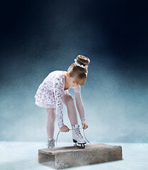 Image showing Little girl figure laces up his shoes indoor ice arena.