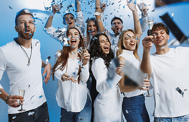 Image showing Group of cheerful joyful young people standing and celebrating together over blue background