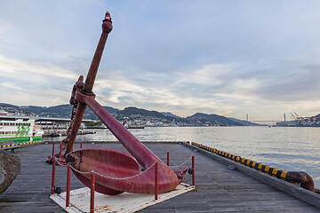 Image showing Big old red anchor on the pier