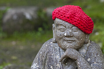 Image showing Old stone statues of Buddhist monks and nuns wearing knitted and cloth hats