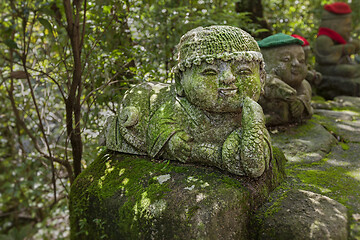 Image showing Snake - symbol of japanese horoscope. Childish Jizo stone statue wearing knitted and cloth hats with zodiac animal.