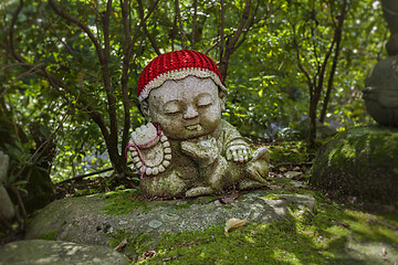 Image showing Dog - symbol of japanese horoscope. Jizo stone statue wearing knitted and cloth hats.