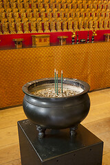 Image showing Burner pot with burning black incense sticks in japanese temple.