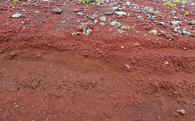 Image showing A cut of soil with rocks and red soil