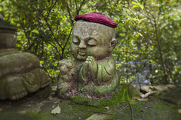 Image showing Rabbit - symbol of japanese horoscope. Childish Jizo stone statue wearing knitted and cloth hats with zodiac animal.