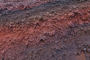 Image showing A cut of soil with rocks and red soil