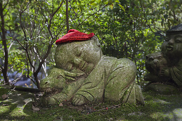Image showing Bull - symbol of japanese horoscope. Childish Jizo stone statue wearing knitted and cloth hats with zodiac animal.