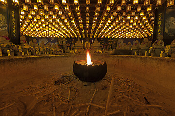 Image showing Burning candle in Burner pot with and incense sticks in japanese cave temple.