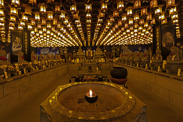 Image showing Burner pot with burning candle and incense sticks in japanese cave temple.