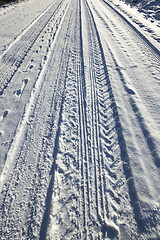 Image showing trace of the car wheels on snow close-up