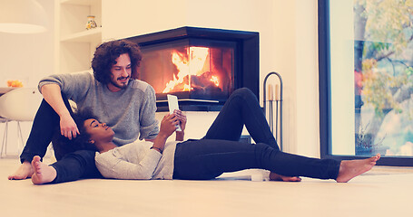 Image showing Young Couple using digital tablet on the floor