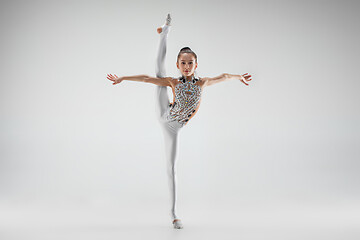 Image showing The teenager girl doing gymnastics exercises isolated on white background