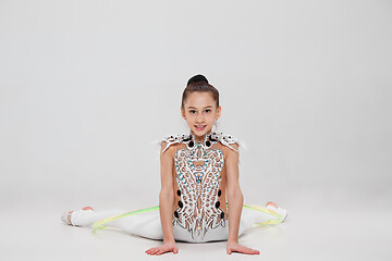 Image showing The teenager girl doing gymnastics exercises isolated on white background