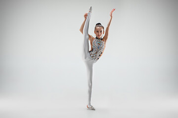 Image showing The teenager girl doing gymnastics exercises isolated on white background