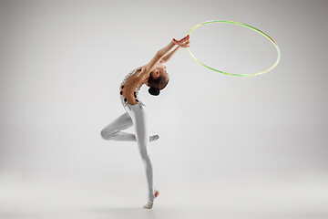 Image showing The teenager girl doing gymnastics exercises isolated on white background