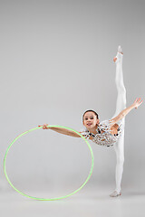 Image showing The teenager girl doing gymnastics exercises isolated on white background