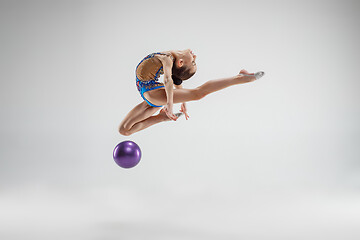 Image showing The teenager girl doing gymnastics exercises isolated on white background