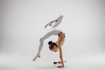 Image showing The teenager girl doing gymnastics exercises isolated on white background