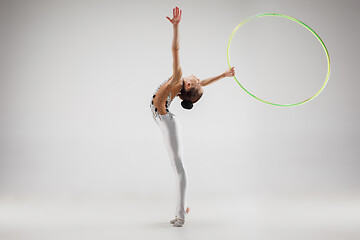 Image showing The teenager girl doing gymnastics exercises isolated on white background