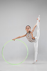 Image showing The teenager girl doing gymnastics exercises isolated on white background