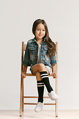 Image showing Full length portrait of cute little kid in stylish jeans clothes looking at camera and smiling