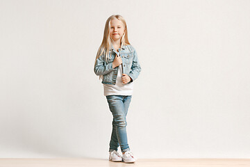 Image showing Full length portrait of cute little kid in stylish jeans clothes looking at camera and smiling