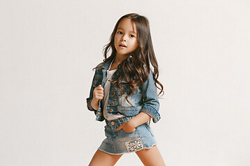 Image showing Full length portrait of cute little kid in stylish jeans clothes looking at camera and smiling