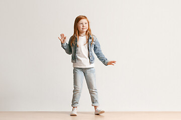 Image showing Full length portrait of cute little kid in stylish jeans clothes looking at camera and smiling