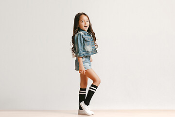 Image showing Full length portrait of cute little kid in stylish jeans clothes looking at camera and smiling