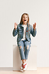 Image showing Full length portrait of cute little teen in stylish jeans clothes looking at camera and smiling