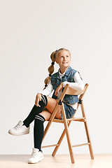 Image showing Full length portrait of cute little teen in stylish jeans clothes looking at camera and smiling
