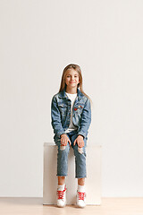 Image showing Full length portrait of cute little teen in stylish jeans clothes looking at camera and smiling