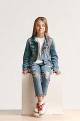 Image showing Full length portrait of cute little teen in stylish jeans clothes looking at camera and smiling