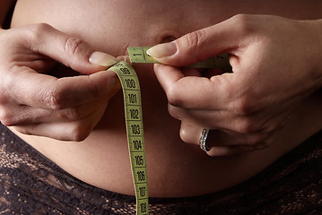 Image showing Frau halten Maßband um Bauch | woman measure belly with tape