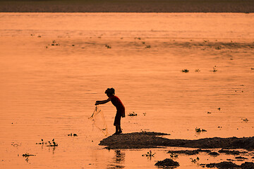 Image showing Asian Woman fishing in the river, silhouette at sunset