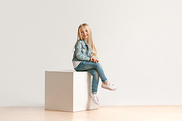 Image showing The portrait of cute little kid in stylish jeans clothes looking at camera and smiling