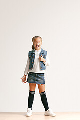 Image showing Full length portrait of cute little teen in stylish jeans clothes looking at camera and smiling