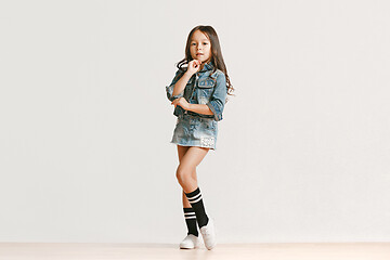 Image showing Full length portrait of cute little kid in stylish jeans clothes looking at camera and smiling