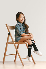 Image showing Full length portrait of cute little kid in stylish jeans clothes looking at camera and smiling