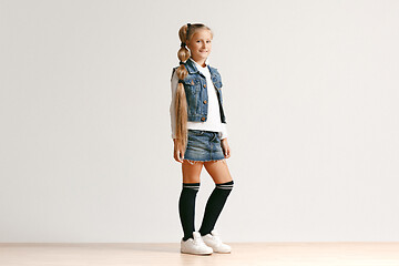 Image showing Full length portrait of cute little teen in stylish jeans clothes looking at camera and smiling