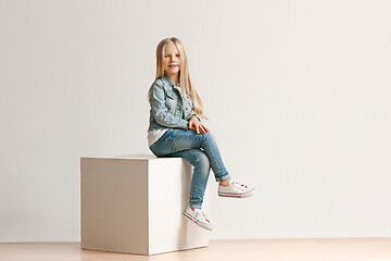 Image showing The portrait of cute little kid in stylish jeans clothes looking at camera and smiling