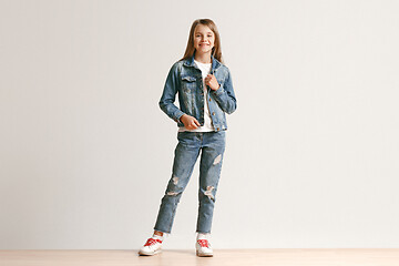 Image showing Full length portrait of cute little teen in stylish jeans clothes looking at camera and smiling