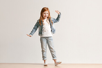 Image showing Full length portrait of cute little kid in stylish jeans clothes looking at camera and smiling