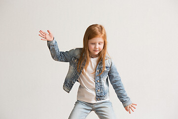 Image showing portrait of cute little kid in stylish jeans clothes looking at camera and smiling