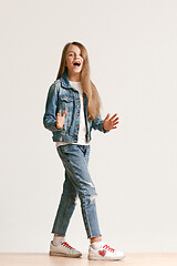 Image showing Full length portrait of cute little teen in stylish jeans clothes looking at camera and smiling
