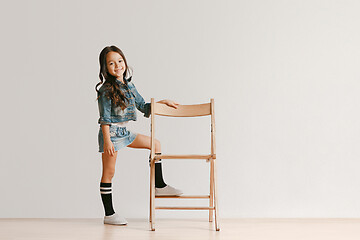 Image showing Full length portrait of cute little kid in stylish jeans clothes looking at camera and smiling