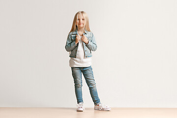 Image showing Full length portrait of cute little kid in stylish jeans clothes looking at camera and smiling